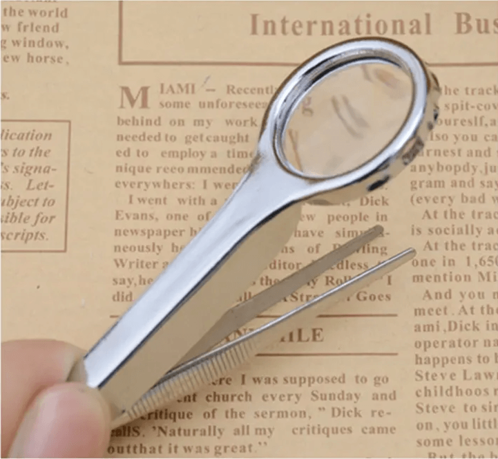 Mini portable handheld magnifying glass with tweezers for jewelry and tiny object inspection.